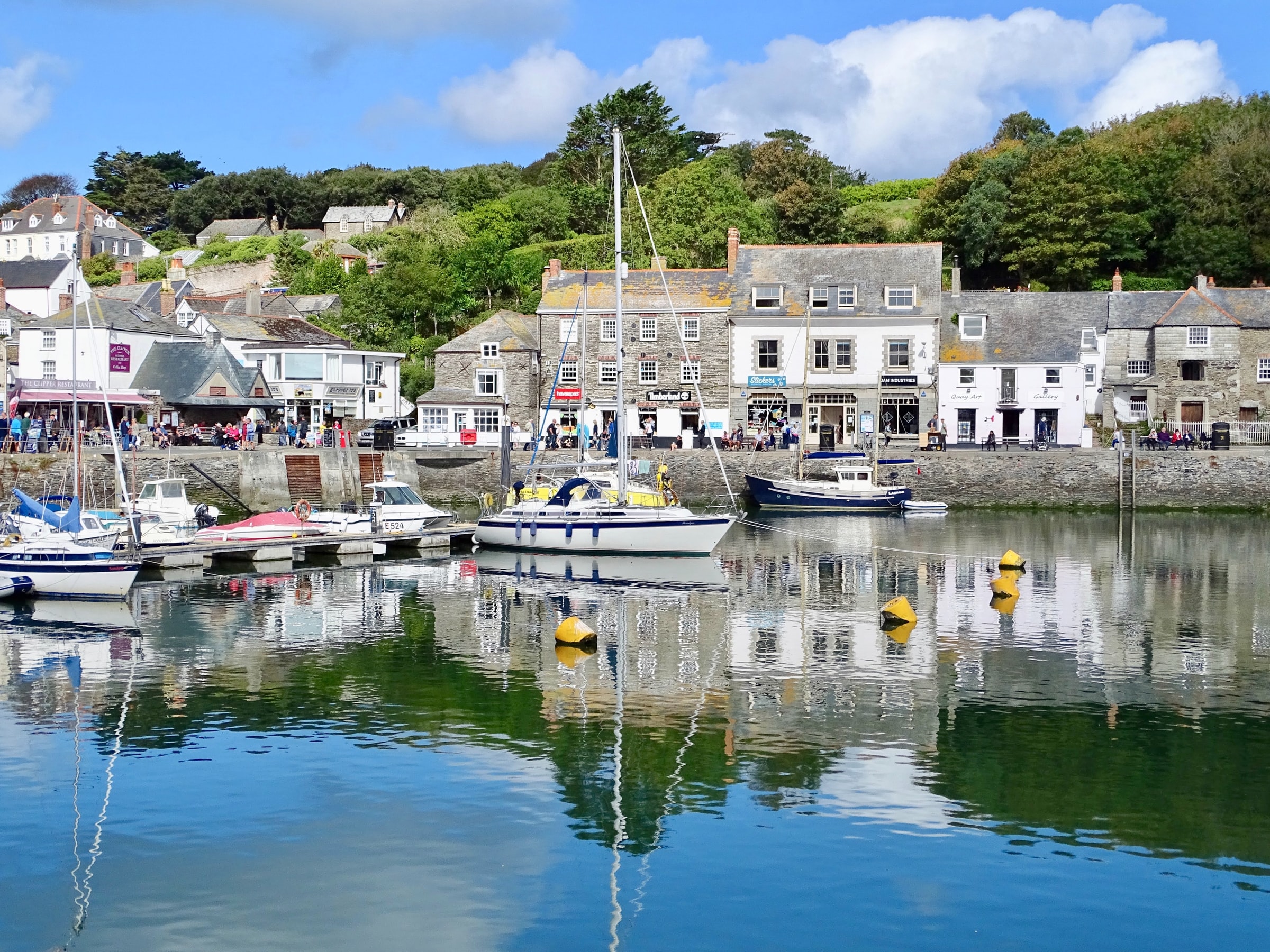 Boats moored in Padstow harbour on the Camel Estuary with waterside shops and caf&eacute;s along the quay