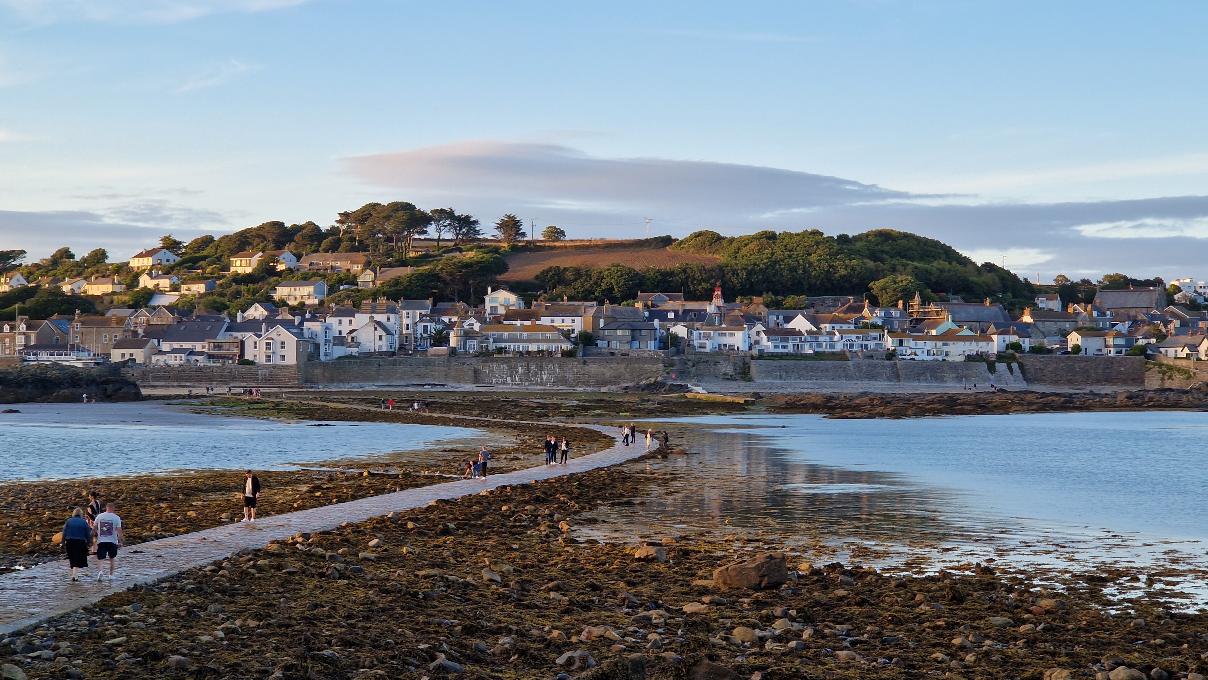 People walking across the stone causeway from Marazion to St Michael&rsquo;s Mount at low tide