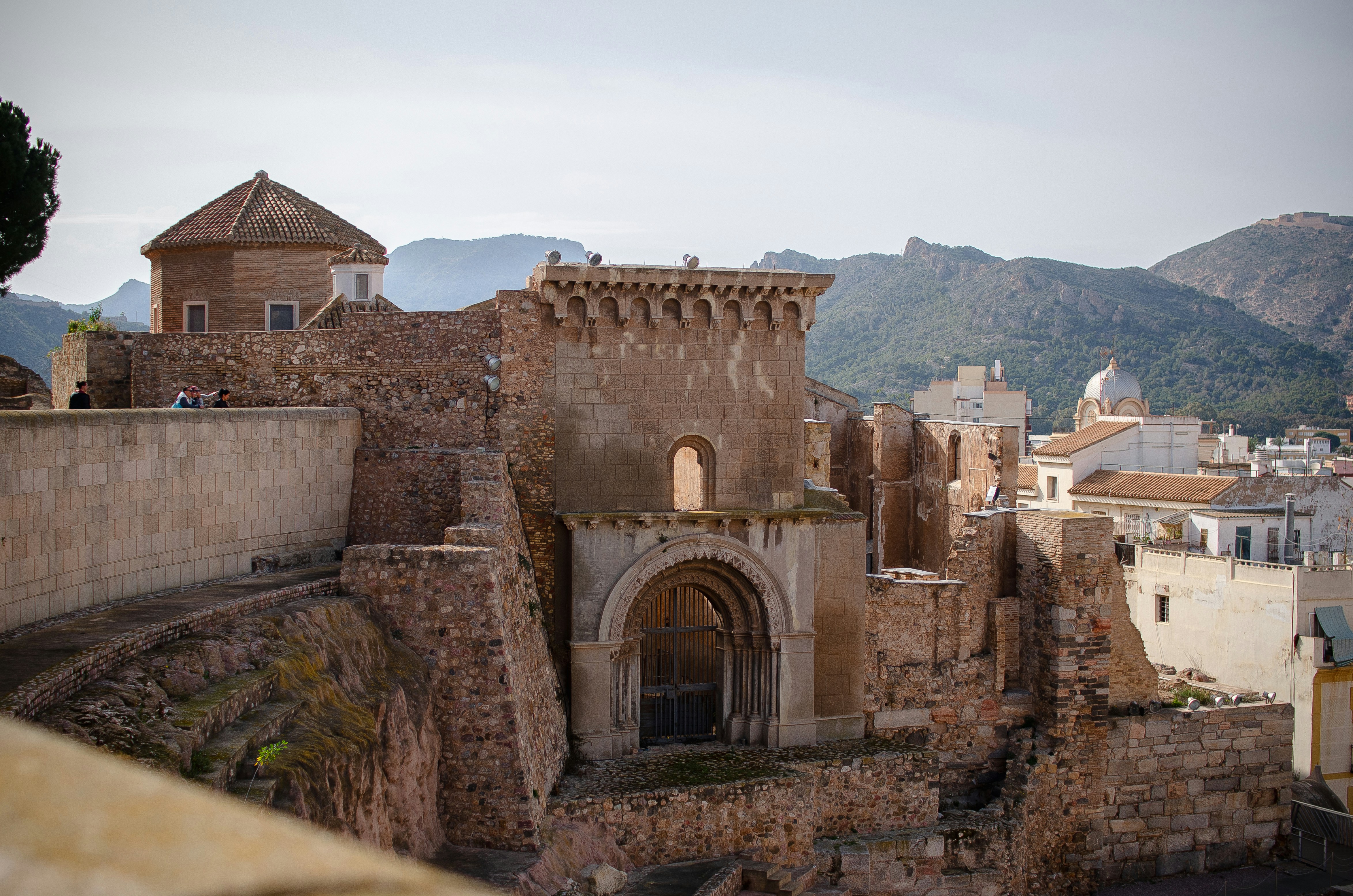 Historic architecture in Cartagena, Murcia region, with stone buildings and hills in the background.