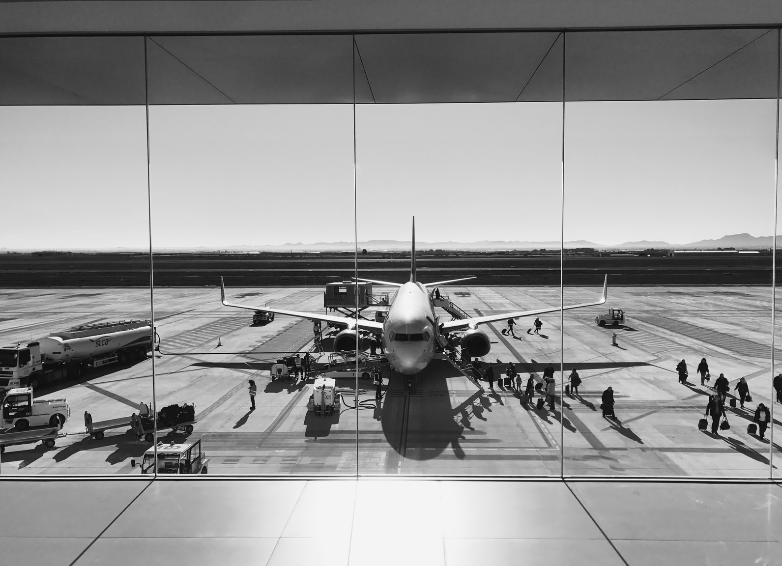 Passenger plane on the runway at Murcia International Airport, viewed from inside the terminal.
