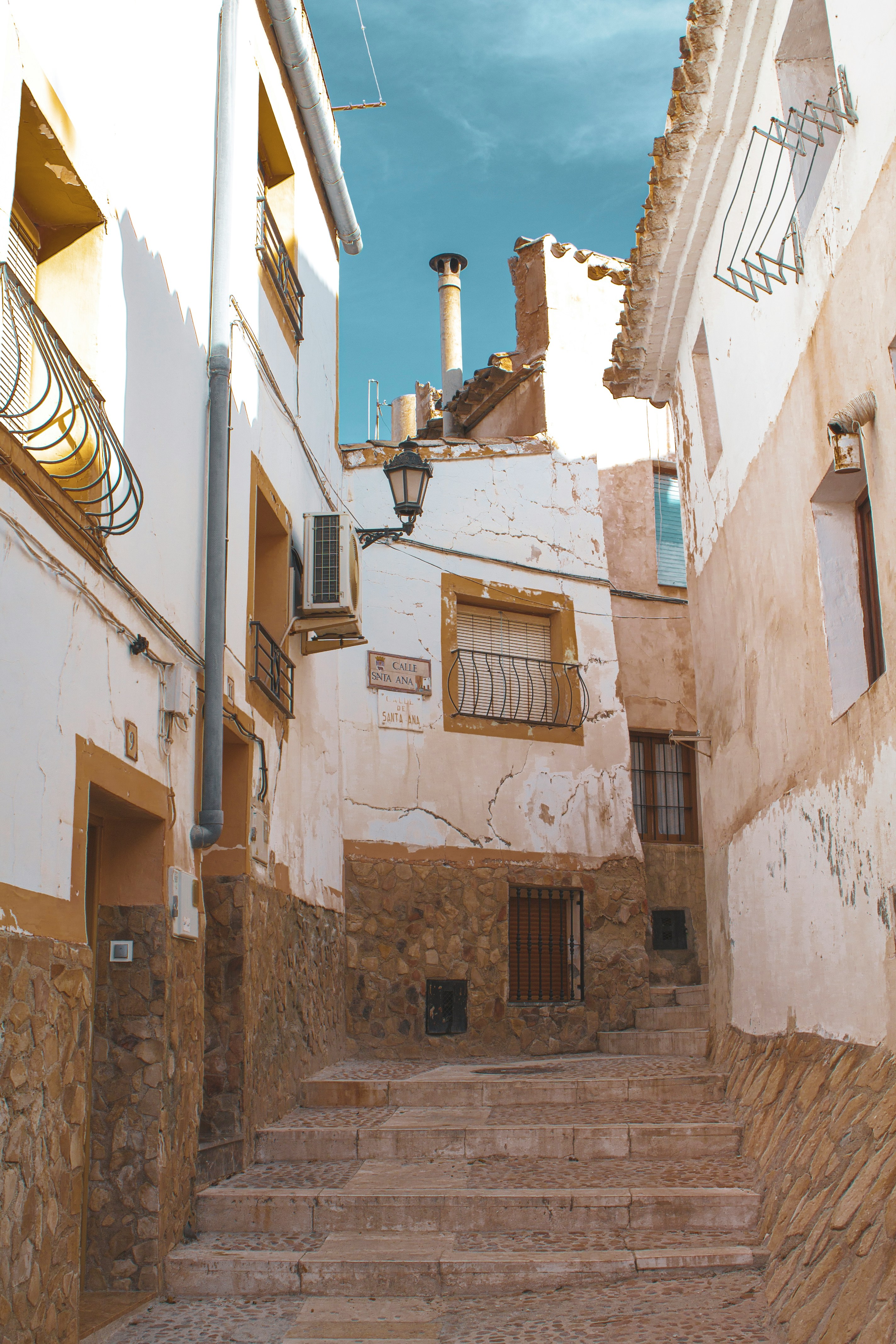 Narrow stepped street in Murcia&rsquo;s Old Town, lined with whitewashed buildings and balconies.