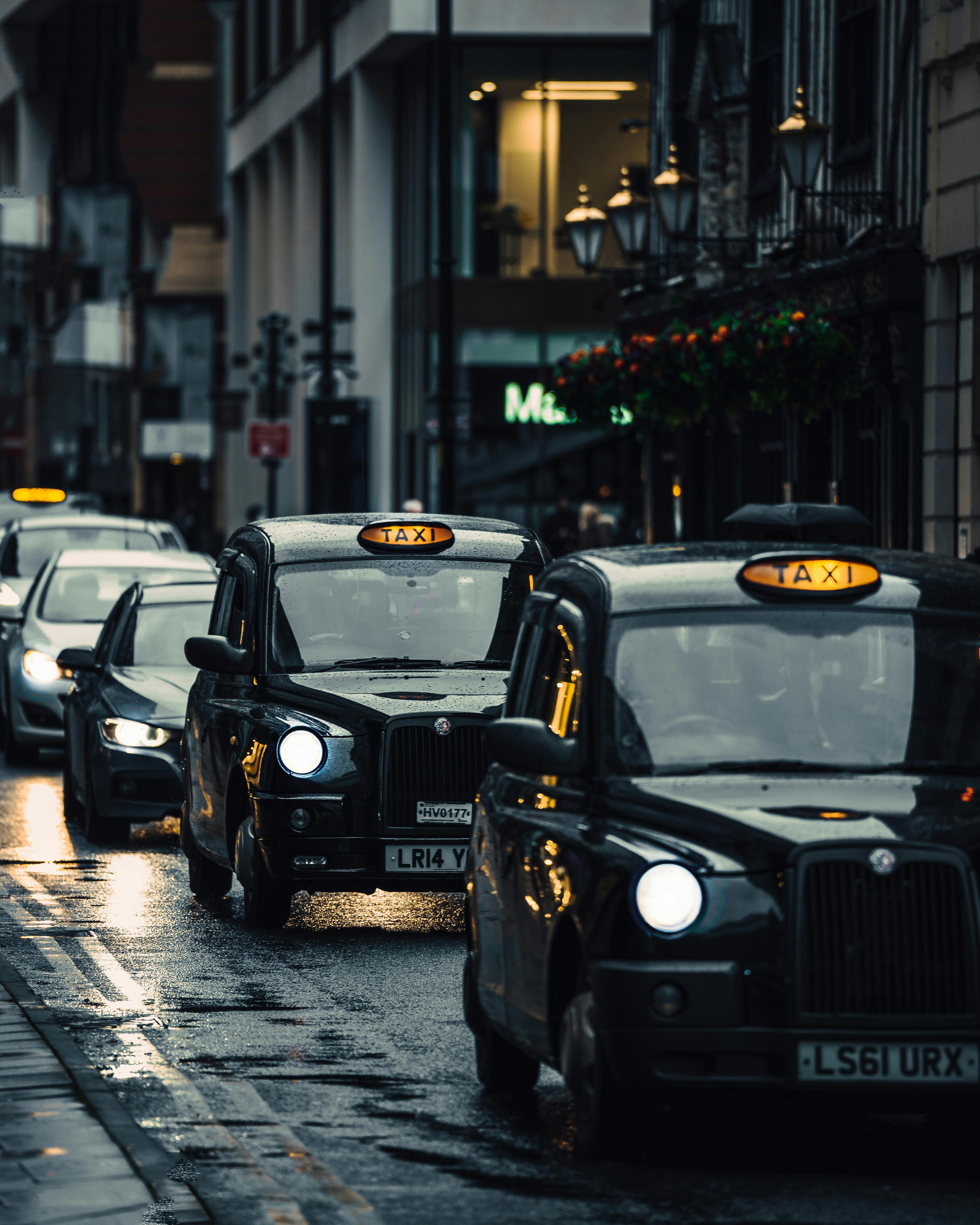 Black cabs moving through wet London traffic, a reminder that driving across the city is not always the easiest way to reach Wimbledon.