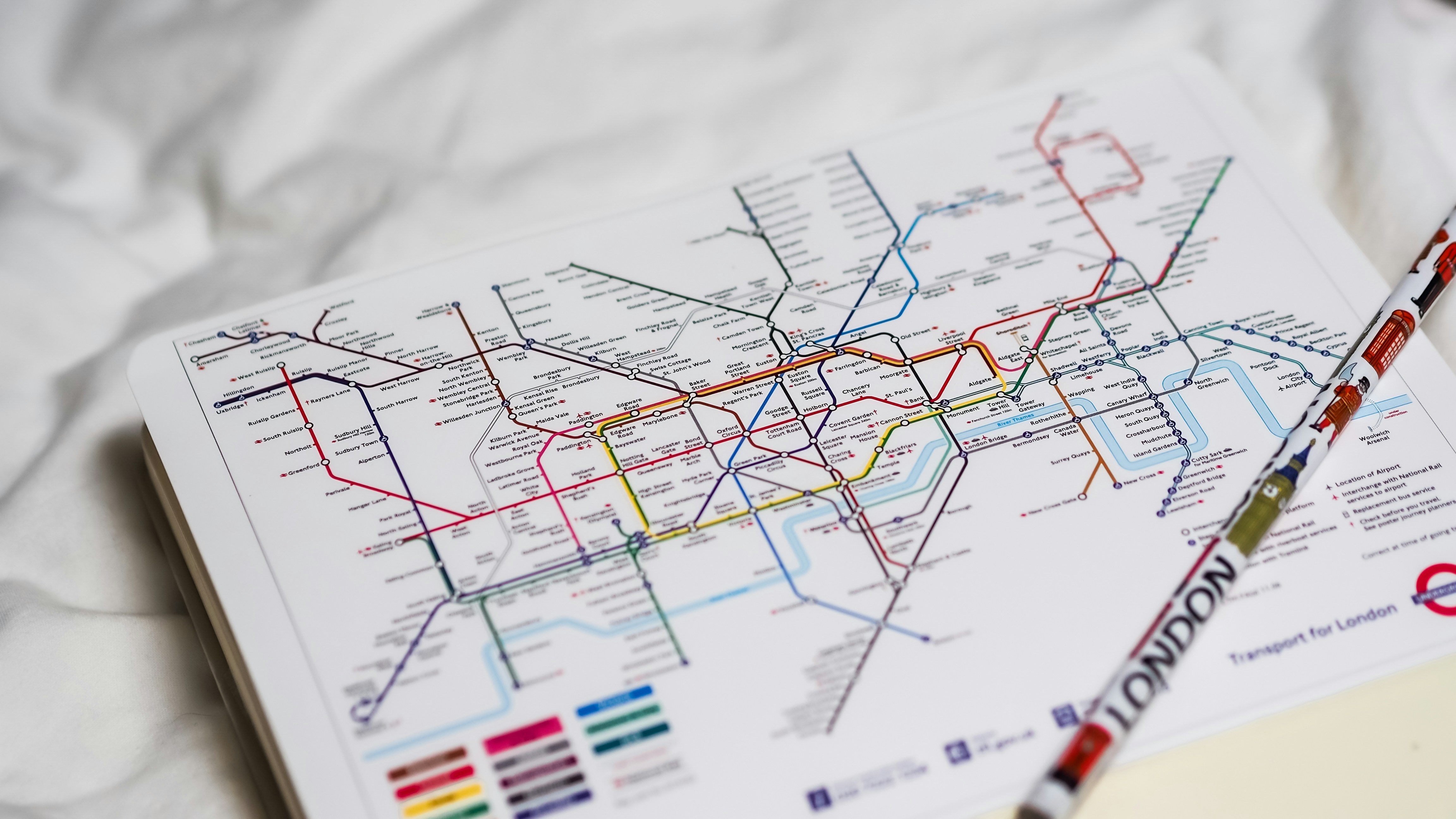 A London Underground map being used to plan journeys across the city, useful for visitors working out the easiest route to Wimbledon.