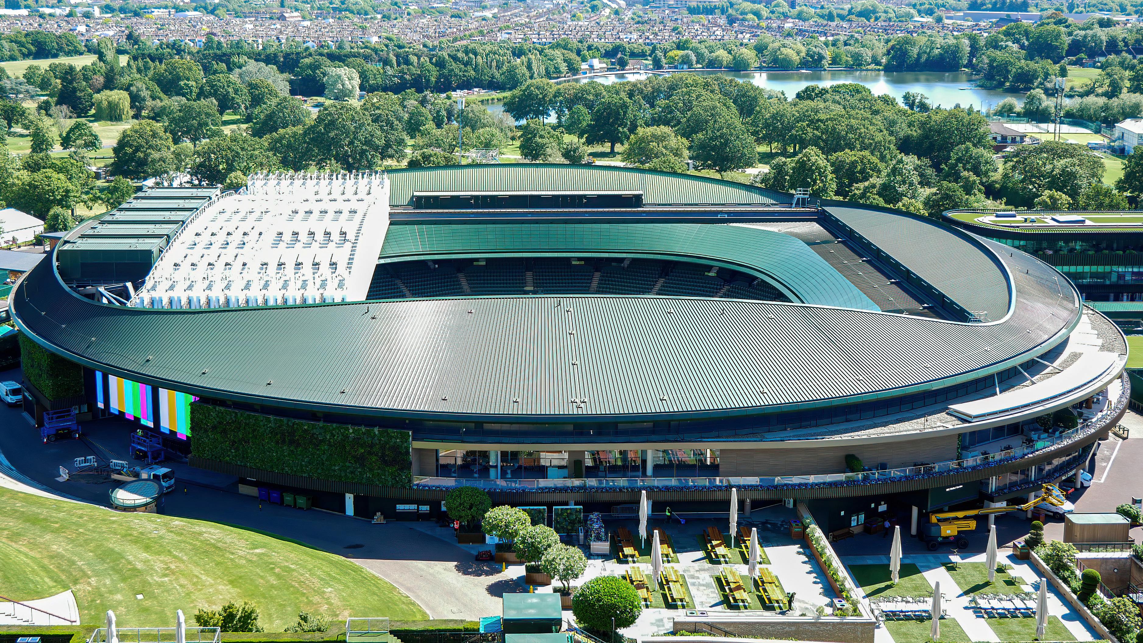 Aerial view of Centre Court at Wimbledon, showing the scale of the Championships within its surrounding green space