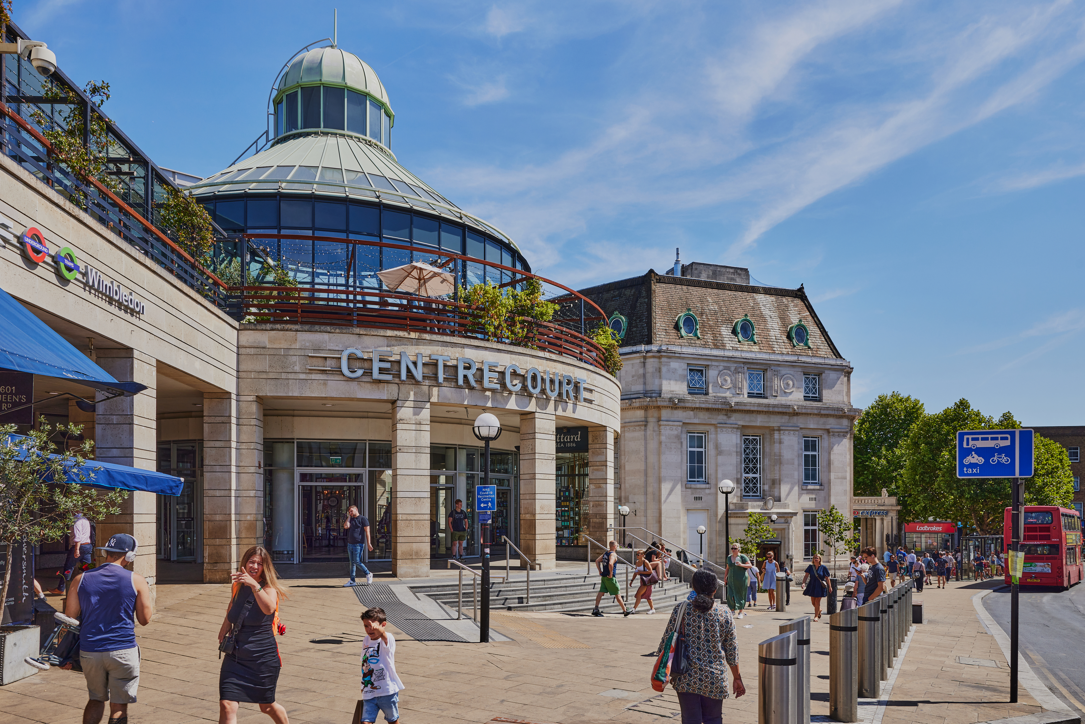 Wimbledon town centre near the station, where pedestrians, buses and local streets show the practical arrival point before the walk uphill towards Wimbledon Village.